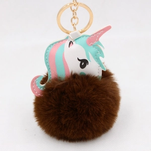 Detail of a brown faux fur pompom and colorful leather unicorn keychain with gold ring