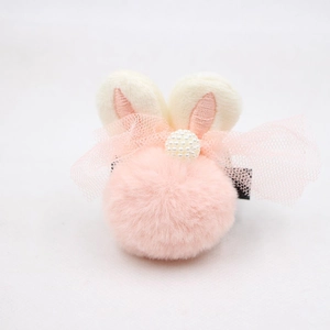 Détail d'une pince à cheveux lapin en peluche rose avec oreilles brodées et perles