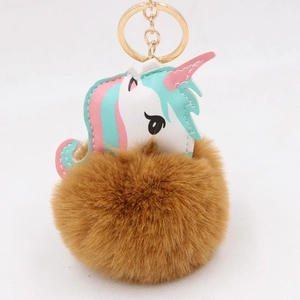 Detail of unicorn bag charm with PU leather head and fluffy brown faux fur pom pom