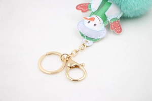 Detail of mint green faux fur pompom keychain with leather snowman charm and gold ring