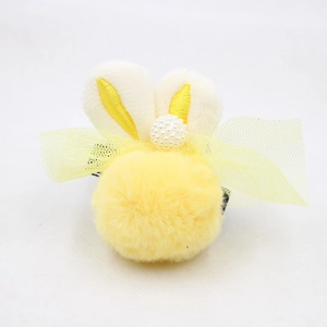 Détail d'une pince à cheveux abeille en peluche avec pompon jaune et petites perles