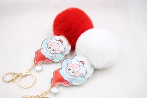 Close-up of Santa Claus pompom keychain with soft faux fur and golden lobster clasp