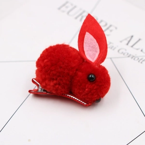 Close-up of a red plush bunny hair clip with 3D ears and a metallic duckbill clip base
