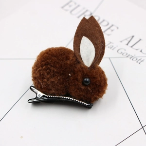 Detail shot of a plush brown bunny hair clip with felt ears and black bead eyes