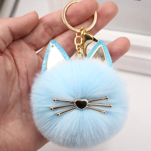 Detail shot of a light blue plush cat keychain with golden whiskers and glitter cat ears