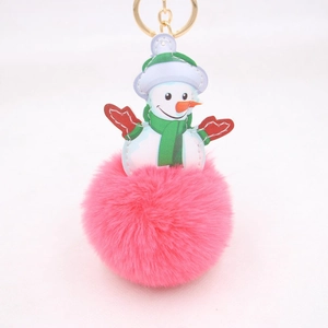 Detail view of pink plush pompom snowman keychain with golden metal clasp and festive design
