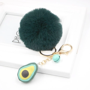 Detail of avocado plush keychain with dark green faux fur ball and gold metal clasp