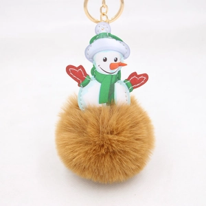 Close-up of fluffy brown faux fur snowman keychain with green scarf and golden hardware
