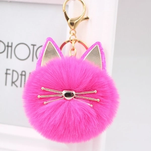 Detailed close-up of vibrant pink plush cat head keychain with gold metal whiskers and ring