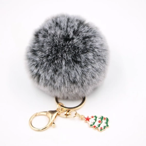 Détail d'un porte-clés pompon en fausse fourrure avec pendentif d'arbre de Noël