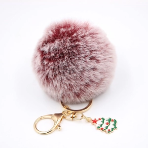 Détail du porte-clés pompon bordeaux avec fermoir doré et pendentif sapin de Noël vert