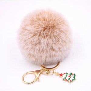 Vue détaillée du porte-clés pompon en fausse fourrure beige avec pendentif sapin de Noël