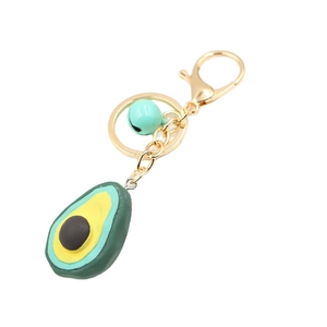Cartoon avocado resin keychain with green fruit shape, blue bell, and gold clasp