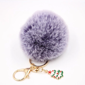 Détail du porte-clés pompon en fausse fourrure violette avec fermoir doré et pendentif sapin