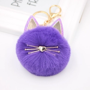 Close-up of a purple plush cat ball keychain with golden whiskers and heart-shaped nose
