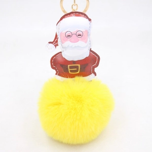 Dettaglio del ciondolo di Babbo Natale in pelle PU con grande pompon in ecopelliccia gialla
