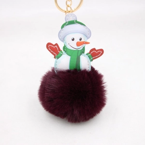 Detail of plush snowman keychain with faux fur pompom and festive leather snowman patch