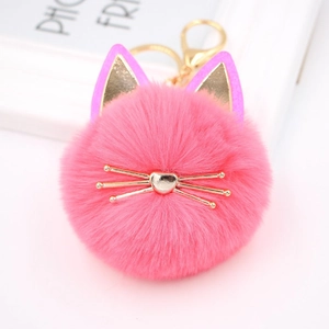 Detailed close-up of bright pink cat plush keychain with gold whiskers and fluffy fur