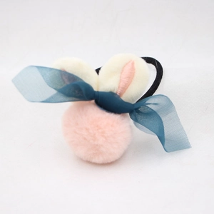 Détail de chouchou lapin en peluche avec pompon rose et nœud en résille bleue