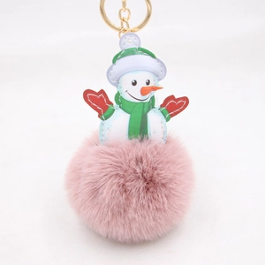 Close-up of pink faux fur snowman keychain with green scarf and gold metal ring