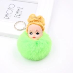 Détail d'un porte-clés poupée mignonne avec pompon vert vif et anneau doré