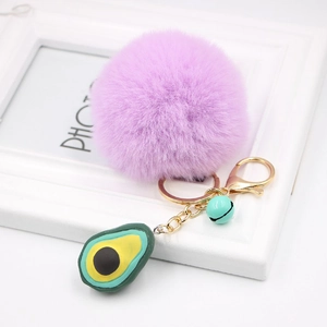 Detail view of purple plush ball keychain with avocado charm and golden metal clasp