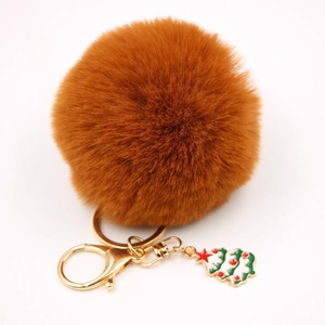 Vue détaillée du pompon marron avec pendentif sapin de Noël doré sur porte-clés élégant