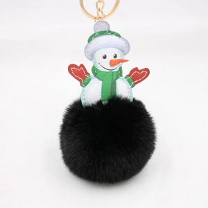 Detail of a Christmas snowman leather pendant with a fluffy black faux fur pompom keychain