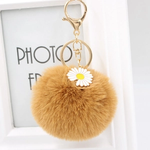 Porte-clés pompon marron avec breloque marguerite blanche et fermoir doré pour sacs