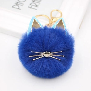 Detail of royal blue fluffy cat plush keychain with gold whiskers and lobster clasp