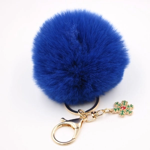 Détail d'un porte-clés pompon bleu marine avec breloque flocon de neige festive