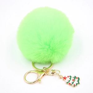 Détail du porte-clés pompon vert en fausse fourrure avec breloque sapin de Noël dorée