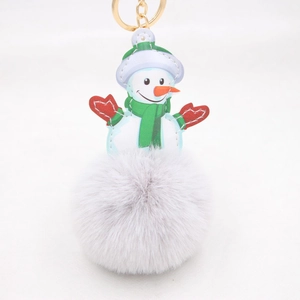 Close-up of snowman faux fur pompom keychain with gold ring and green scarf detail