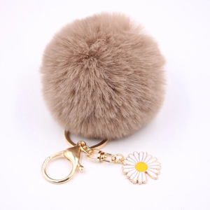 Détail du porte-clés pompon en fausse fourrure kaki avec breloque marguerite dorée