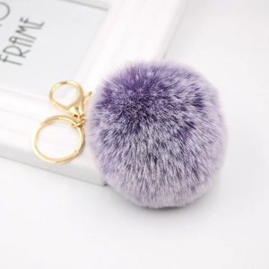 Faux fur pompom keychain in gradient purple with gold lobster clasp on white background