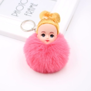 Vue détaillée d'un porte-clés pompon rose vif avec une tête de poupée blonde mignonne