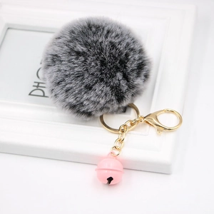 Close-up of fluffy faux rabbit fur keychain with pink bell and golden lobster clasp