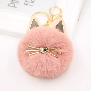 Close-up of a pink plush cat head keychain with gold metal clasp and heart-shaped nose