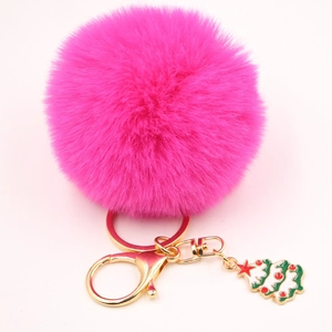 Porte-clés pompon en fausse fourrure rose vif avec un charme d'arbre de Noël festif