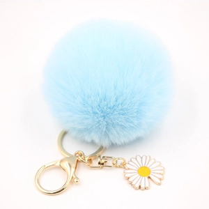 Détail du porte-clés pompon bleu clair avec fermoir doré et pendentif marguerite blanche