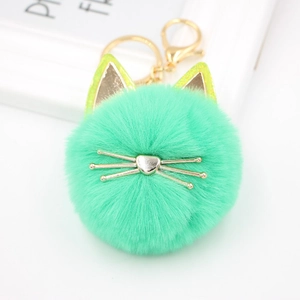 Close-up of mint green plush cat head keychain with gold ears and heart-shaped nose