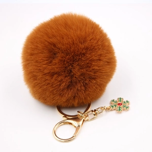 Détail d'un porte-clés en fausse fourrure marron avec flocon doré et fermoir homard
