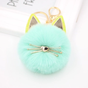 Close-up of mint green plush cat keychain with golden whiskers and heart nose