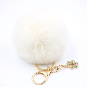 Détail d'un porte-clés pompon blanc avec pendentif festif de flocon de neige de Noël
