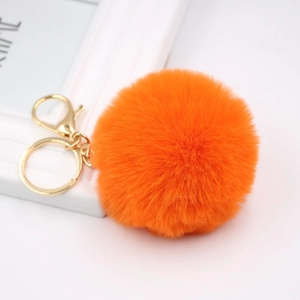 Detailed macro view of 8cm bright orange faux rabbit fur pompom with golden metal clasp