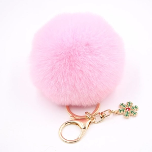 Vue détaillée d'un porte-clés pompon rose avec breloque flocon de neige vert et fermoir doré