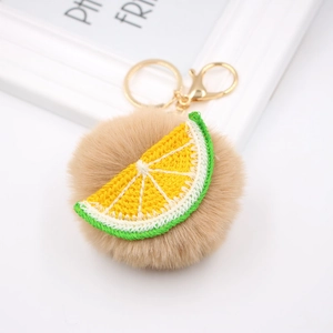 Détail de broderie de citron sur porte-clés pompon avec mousqueton en métal doré