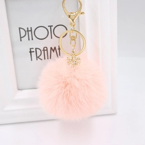 Detail of pink plush keychain with gold alloy snowflake charm and lobster clasp