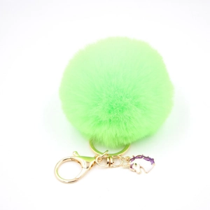 Detail of neon green faux fur pompom keychain with golden unicorn pendant and clip