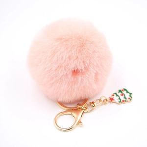 Détail du porte-clés en fourrure rose avec un petit pendentif festif en forme de sapin
